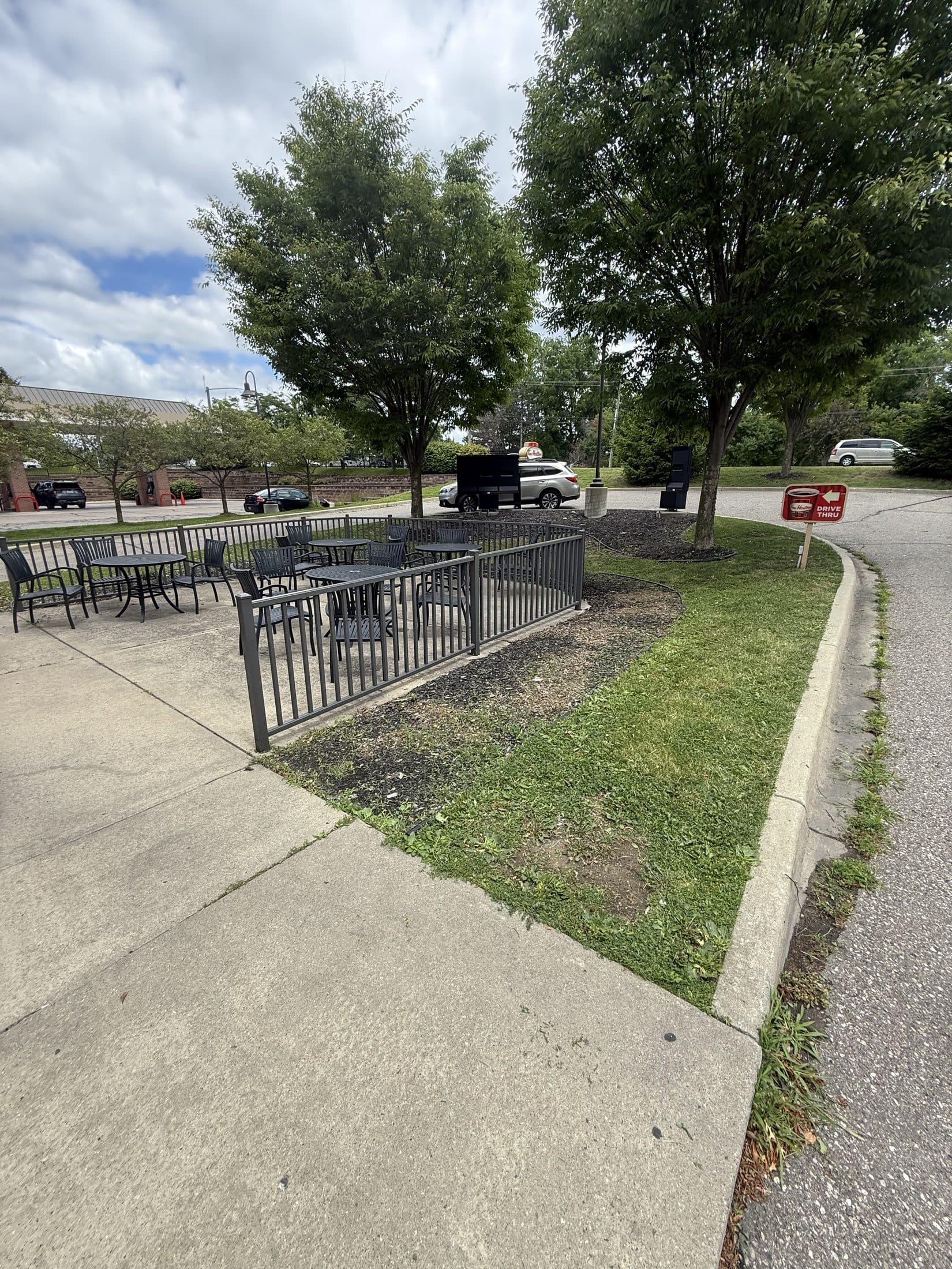 A freshly mowed commercial lot bordered by black fencing